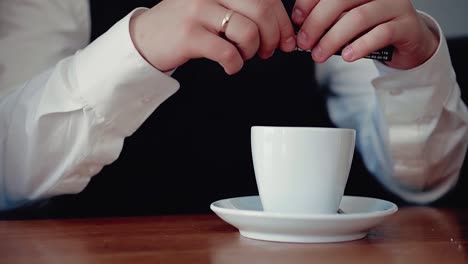 young man pours sugar into a glass