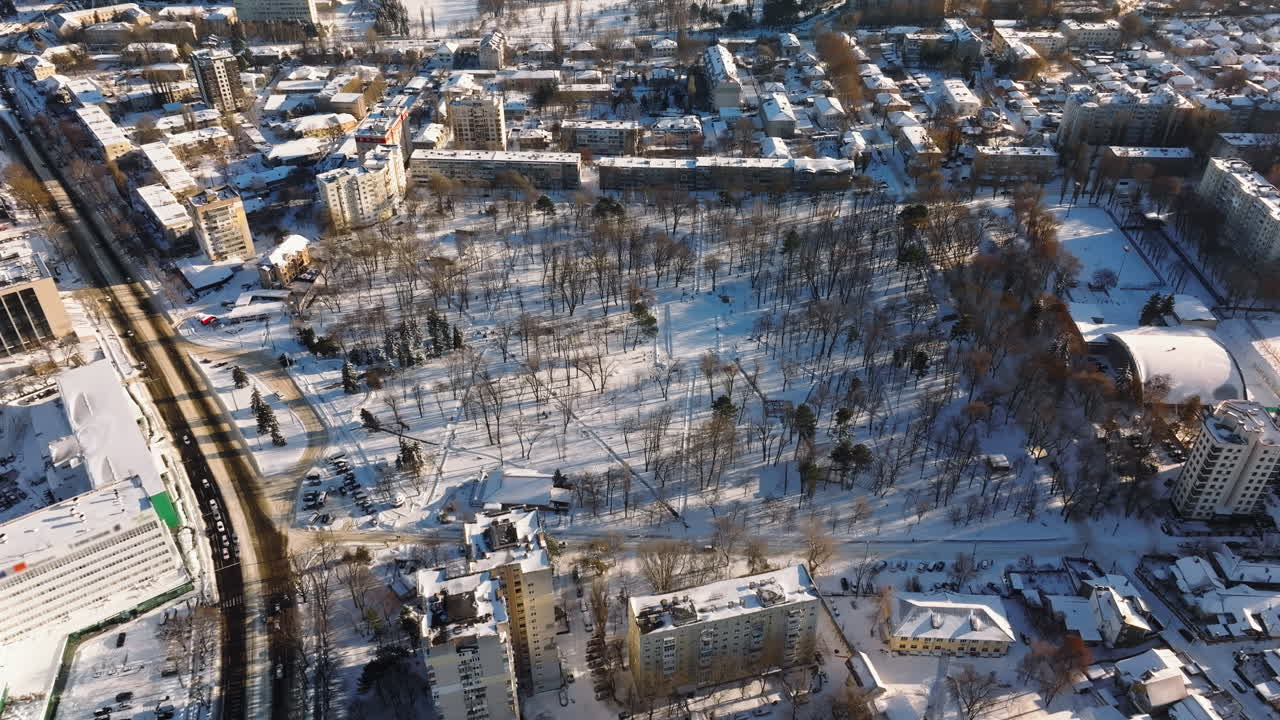 Aerial drone view of the city park covered in snow. Sunrise during winter in Chisinau, Moldova