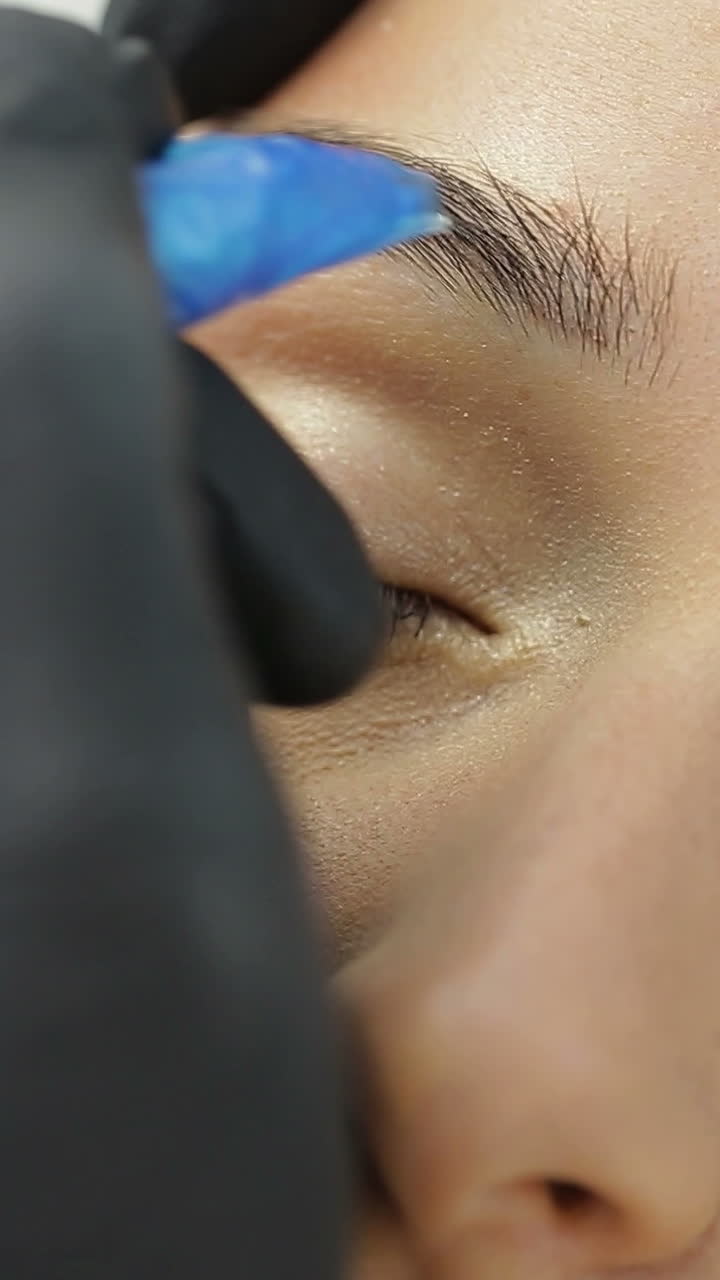 Permanent Tattooing Of Eyebrows. Cosmetologist applying permanent make up on eyebrows
