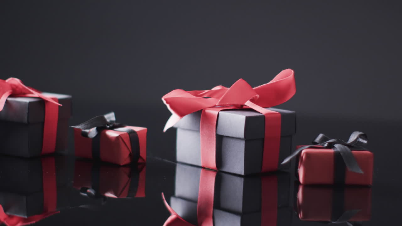 video de cajas de regalos con cinta roja y negra y espacio de copia sobre fondo negro