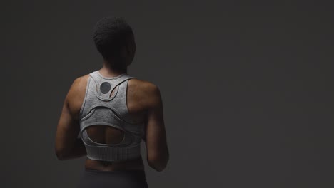 rear view studio shot of young woman wearing gym fitness clothing for exercise