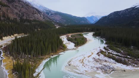 Northern-British-Columbia-frozen-river-with-mountains,-aerial-drone