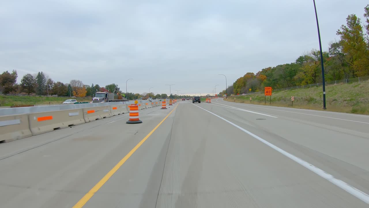 pov mientras conduce a través de un sitio de construcción en la interestatal i74 cerca del río mississippi a fines del otoño en un día nublado en moline, illinois