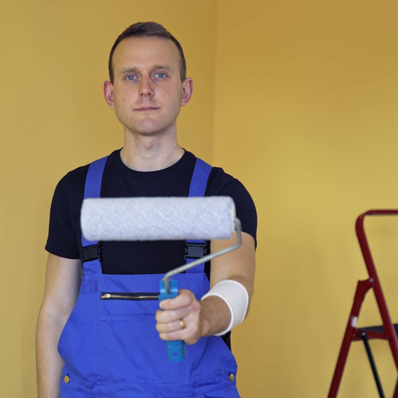 Young professional painter get ready for work. Handsome man doing apartment renovation