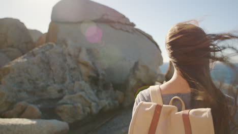 playa, viajes y mujer caminando sobre rocas