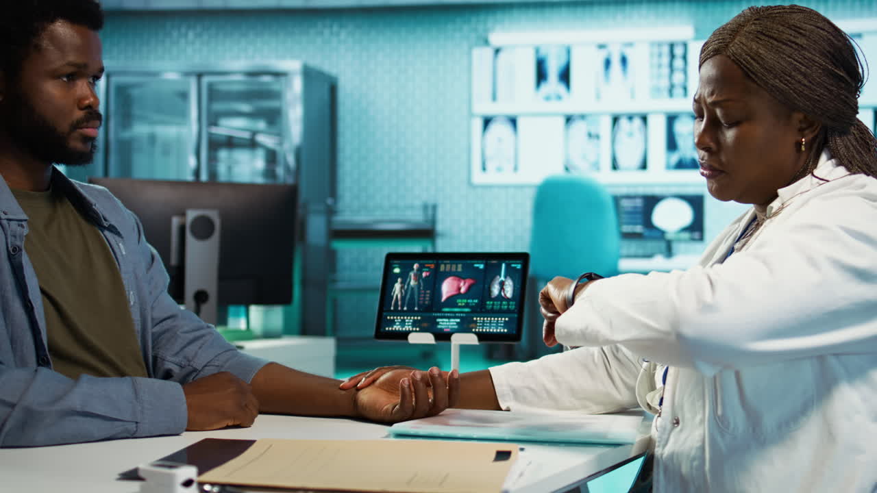 Physician measuring the heart rate of a young man by using her smartwatch