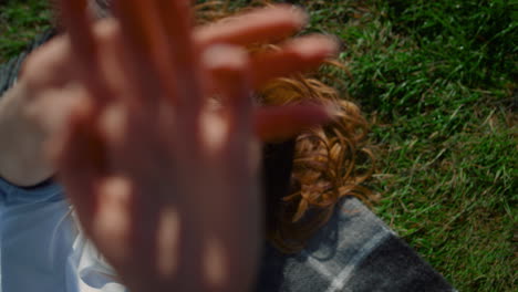 Closeup-woman-hands-in-green-grass-background.-Playful-female-stretching-hands.