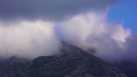 Clouds-splashing-on-high-mountain-rocky-slope-creating-beautiful-scenery-timelapse