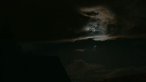 timelapse of shining full moon in dark clouds in east berlin, germany