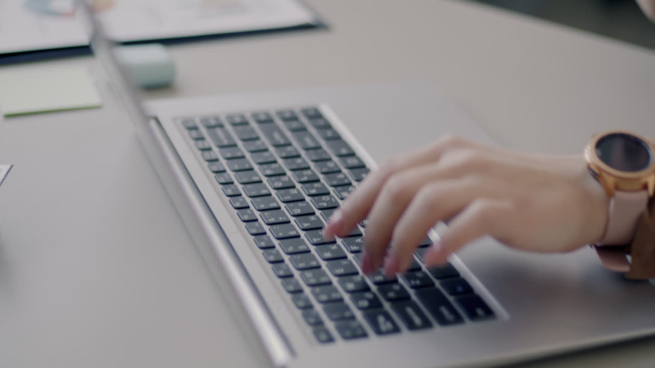 Woman working on laptop and on phone call in office