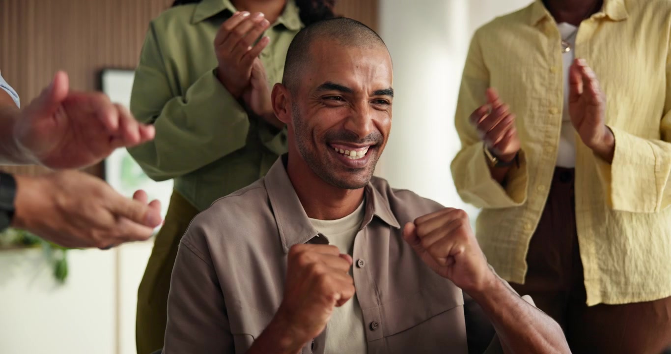 Uomo felice che festeggia il successo con i colleghi che applaudono in ufficio
