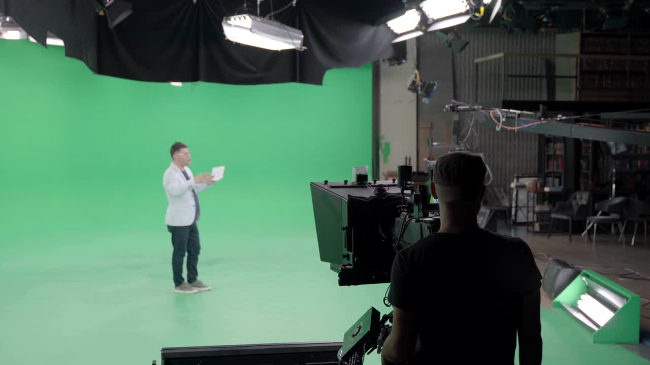 equipo de filmación en el estudio verde de rodaje de video. croma - tecnología de combinar dos o más imágenes o cuadros en una sola composición. camarógrafo, director, equipo. industria cinematográfica.