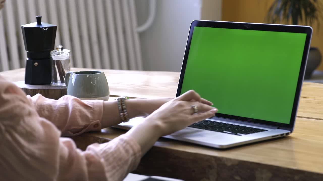 mujer trabajando en una computadora portátil con pantalla verde