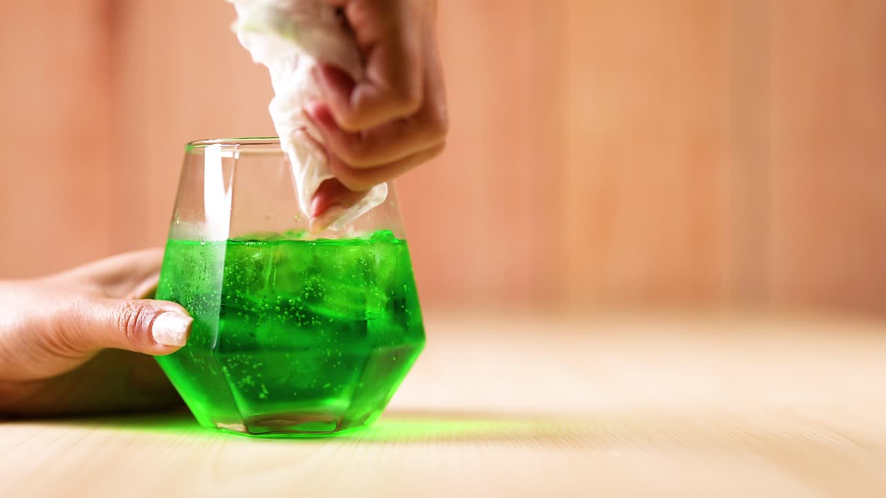 녹색 액체로 가득 찬 손 청소 유리