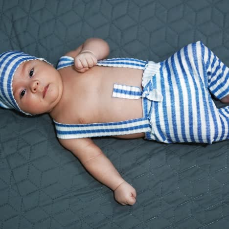 nice child in a funny costume of a gnome. infant in a striped suit at the grey background. view from above