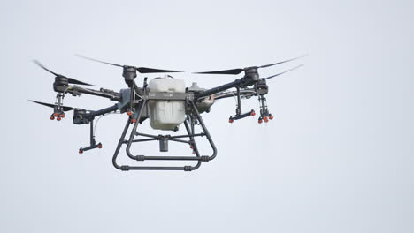 close-up shot of a dji agras t30 hovering over a field ready to start spraying