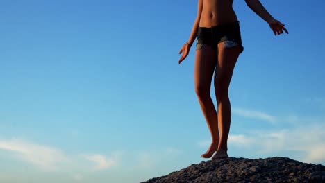 female volleyball player standing on a rock in the beach 4k