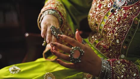 putting on her beautiful traditional rings is an asian bride, close up view