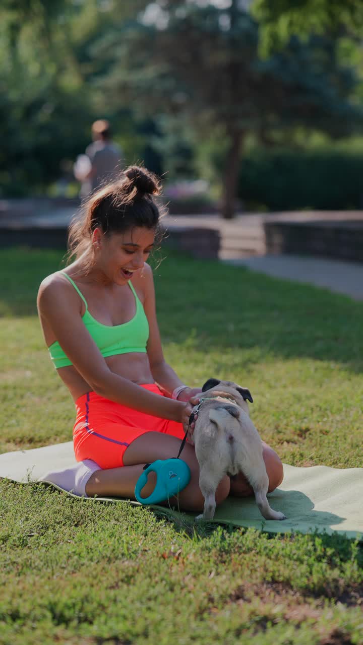 mujer haciendo ejercicio con su pug en un parque