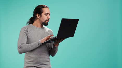 hombre componiendo correo electrónico, escribiendo en el teclado de la computadora portátil, emocionado de cerrar la sesión después del trabajo