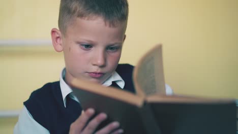 upset-boy-turns-pages-of-textbook-preparing-for-test-at-home