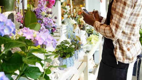 florista mujer tomando una fotografía de flores con un teléfono móvil