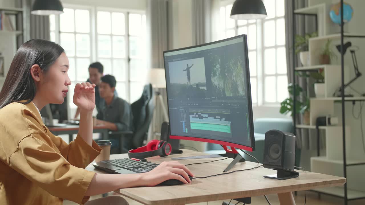 Tired Asian Female Video Editor Works With Footage And Sound On Her Personal Computer In Office
