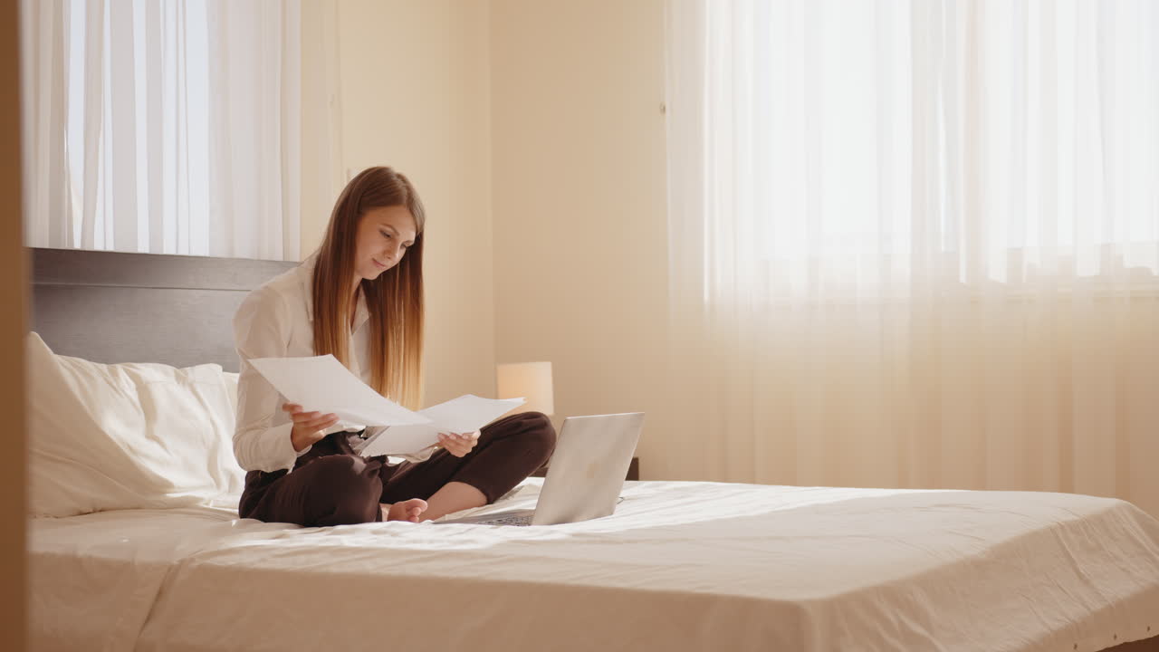 침대에 노트북으로 일하는 여자