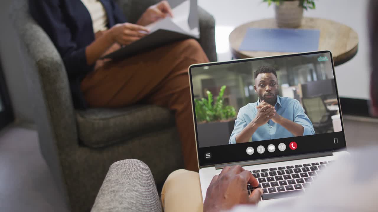 African american man using laptop for video call, with business colleague on screen