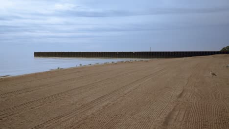 Sea-beach-with-sea-gulls-and-pier.-Sea-beach-background.-Seagulls-on-beach