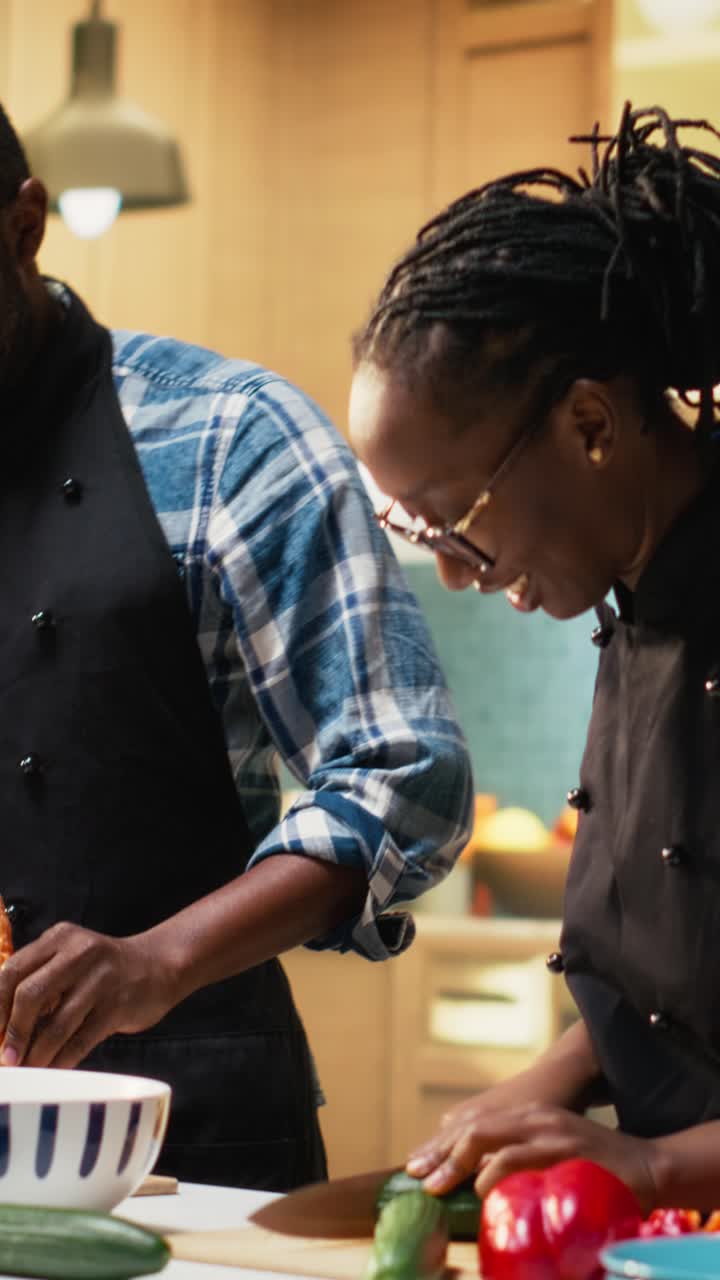 Vertical Video Happy couple cutting fresh vegetables on a cutting board in the kitchen