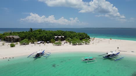 pan de camiones aéreos a lo largo de la isla de patawan revela el barco banca y el bungalow junto a la playa