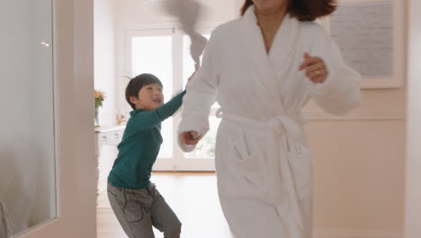 happy-little-asian-boy-playing-catch-with-mother-running-through-house-enjoying-fun-weekend-morning-with-child-4k-footage