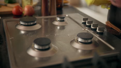 woman cleaning a gas stove