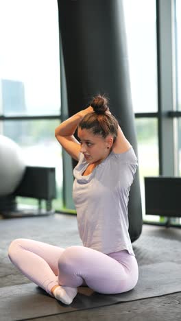 mujer estirándose en un gimnasio