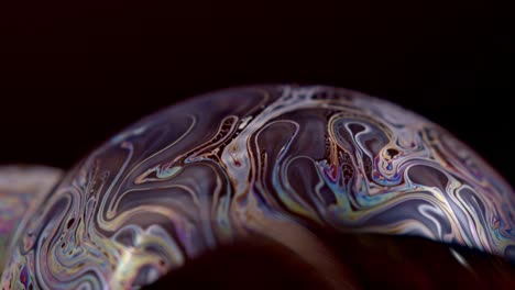 Closeup of a bubble with rainbow colored templates in it and animation for example for backgrounds
