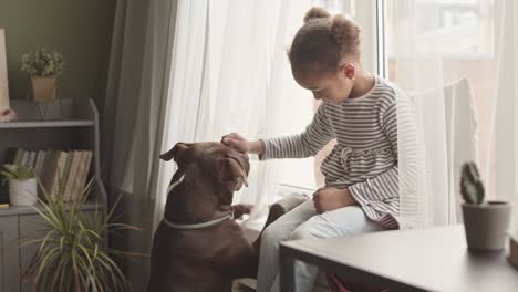 african american girl playing with her dog at home