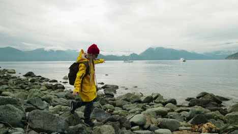 woman hiking on a rocky beach in cloudy weather