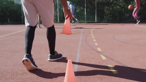 Diverses-Training-Der-Weiblichen-Basketballmannschaft-Mit-Männlichem-Trainer-Auf-Sonnigem-Platz,-Kopierraum,-Zeitlupe