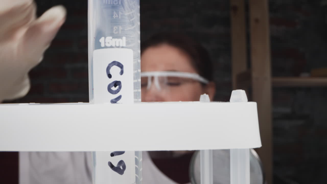 과학자는 혈액  ⁇ 플과 코로나라는 단어를 가진 시험관을 넣습니다.