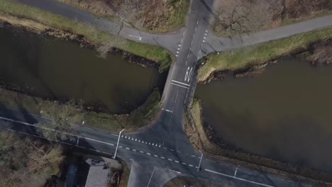 Drehende-Drohnenaufnahme-Des-Kreuzungspunktes-Mit-Kanal-Und-Autos