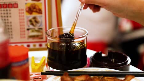 hand stirring chili sauce at street food stall