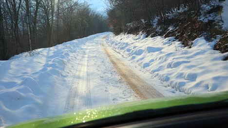 Car-driving-fast-on-snow-ice-slippery-covered-narrowed-mountains-road-path,-adrenaline-speed-extreme-driving-winter-conditions-with-snow-chains