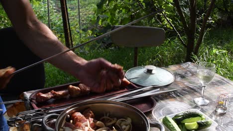 man's hand take raw meat shish kebab and string it on metal skewers in unhygienic conditions