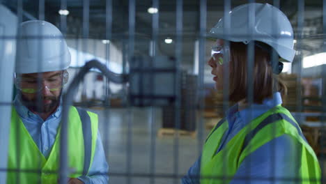 Especialistas-En-Fabricación-Discutiendo-La-Producción-Inspeccionando-El-Almacén-De-Productos.