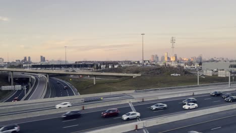autopista de toronto con tráfico de automóviles y el horizonte de la ciudad en el fondo al atardecer, canadá