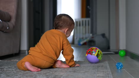 baby crawling and playing with a ball