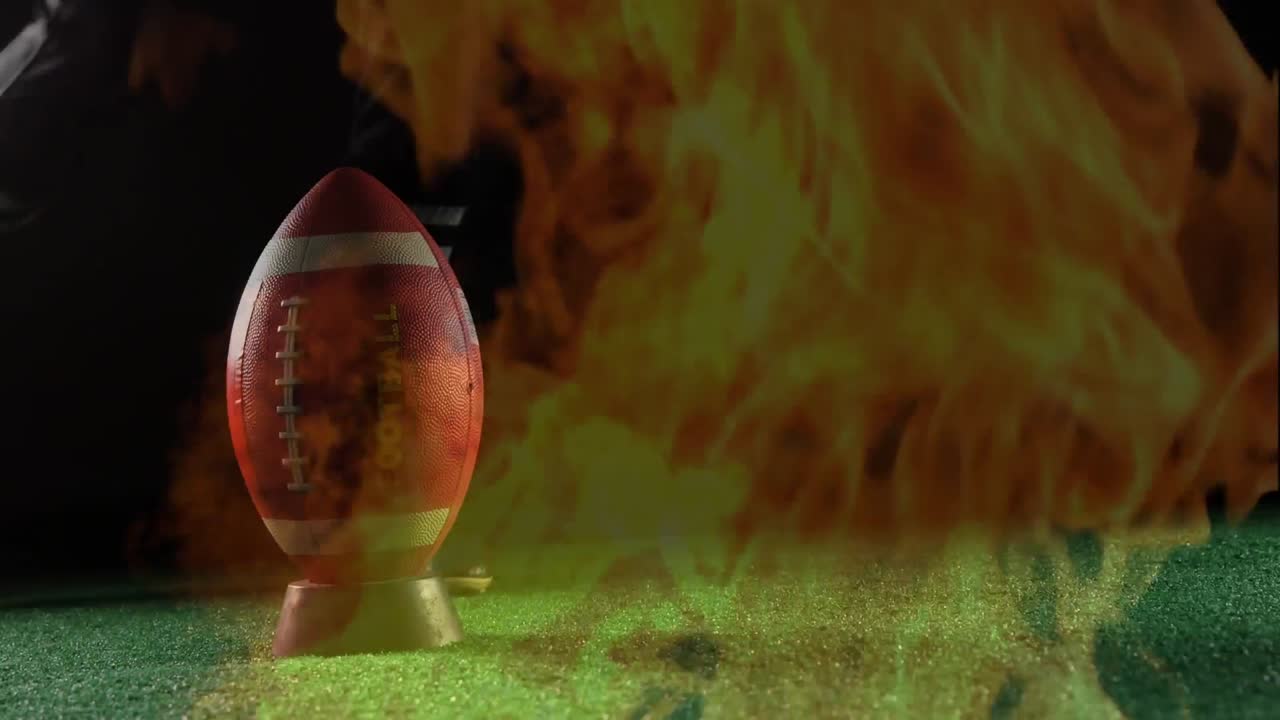Pallone da football su un supporto e fuoco che brucia.