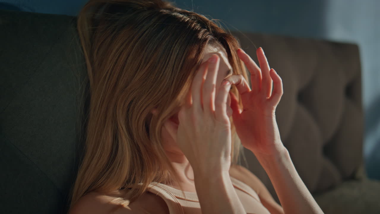 Awaking woman sitting bed opening eyes after sleep close up. Sleepy girl waking