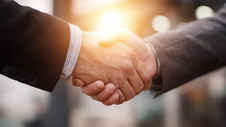 A Moment of Agreement: Two Business Professionals Engaging in a Firm Handshake as a Symbol of Partnership, Trust, and Mutual Understanding in a Professional Environment